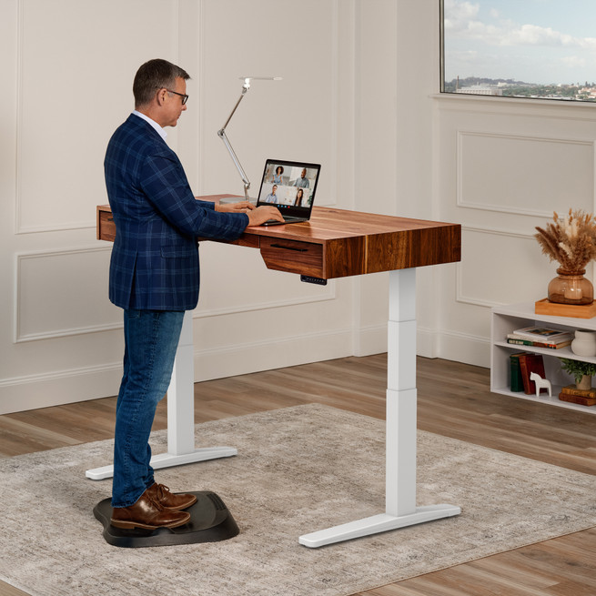 UPLIFT V3 Narrative standing desk with a 60 × 30-inch Rustic Walnut solid-wood top and white frame.