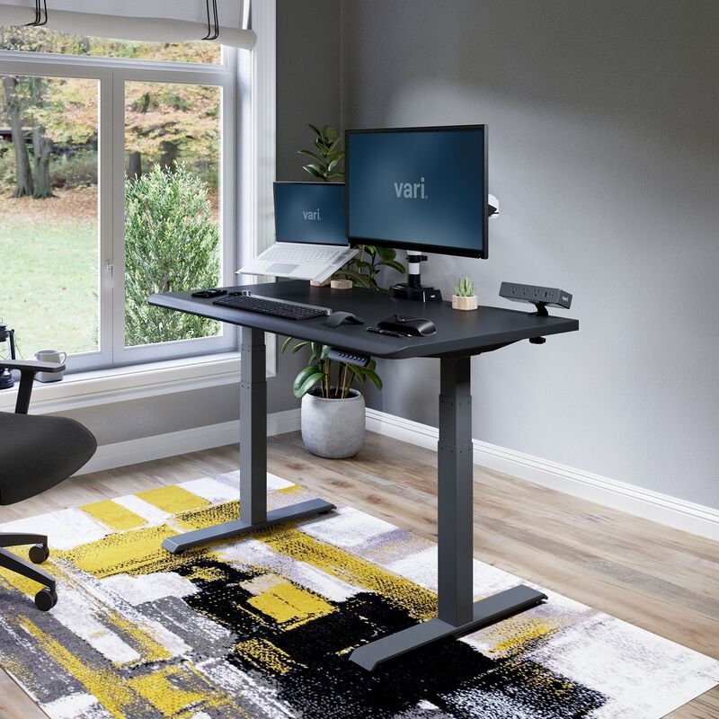 Vari Electric Standing Desk with ComfortEdge 48x30 in Black/Slate, raised in a staged home office