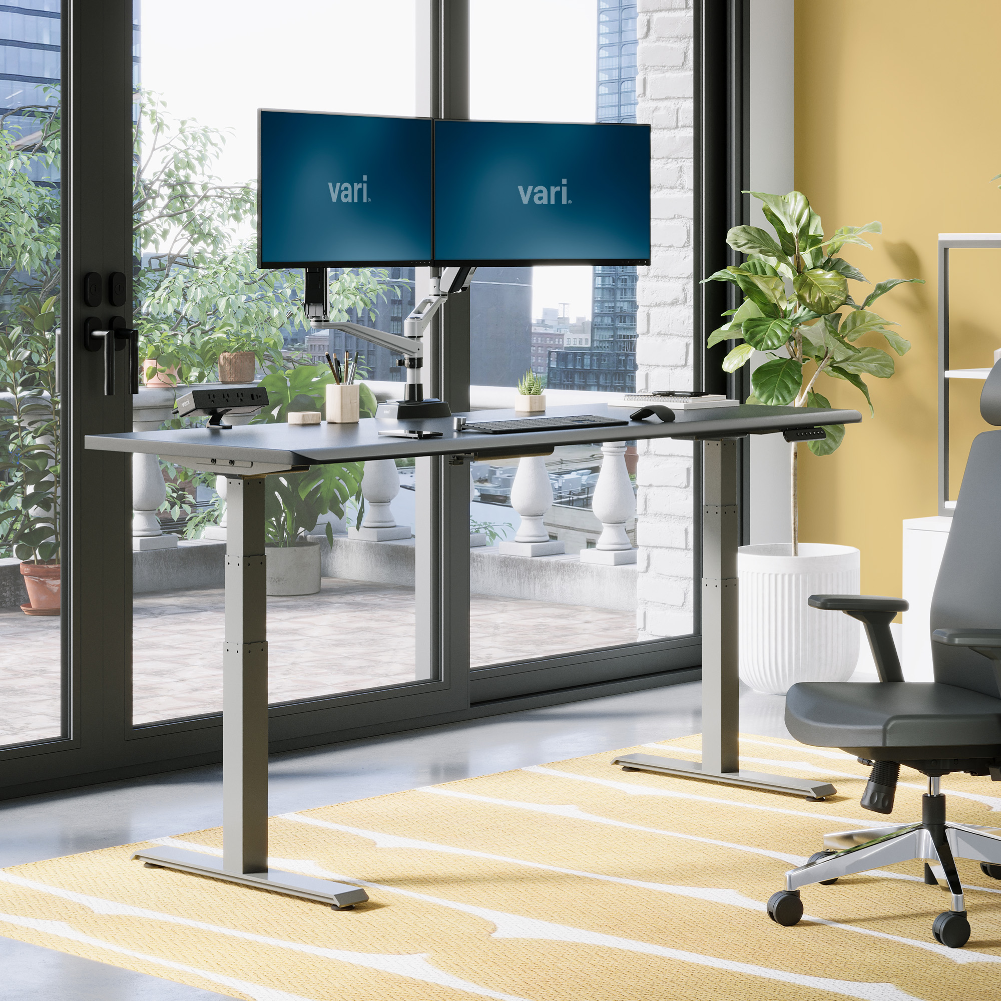 Vari ComfortEdge 72x30 electric desk in Black/Slate finish, raised in a staged office