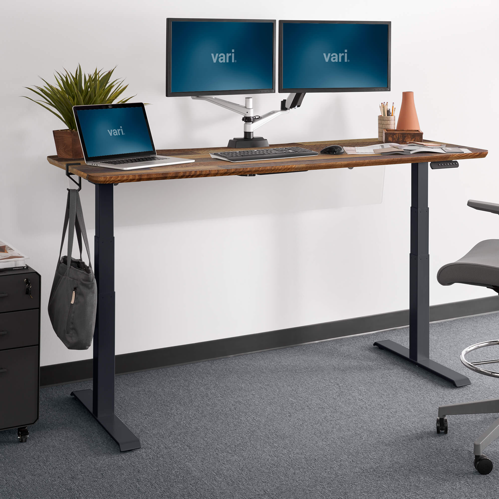 Vari Electric Standing Desk 72x30, Reclaimed Wood/Slate laminate top, raised in a staged workspace