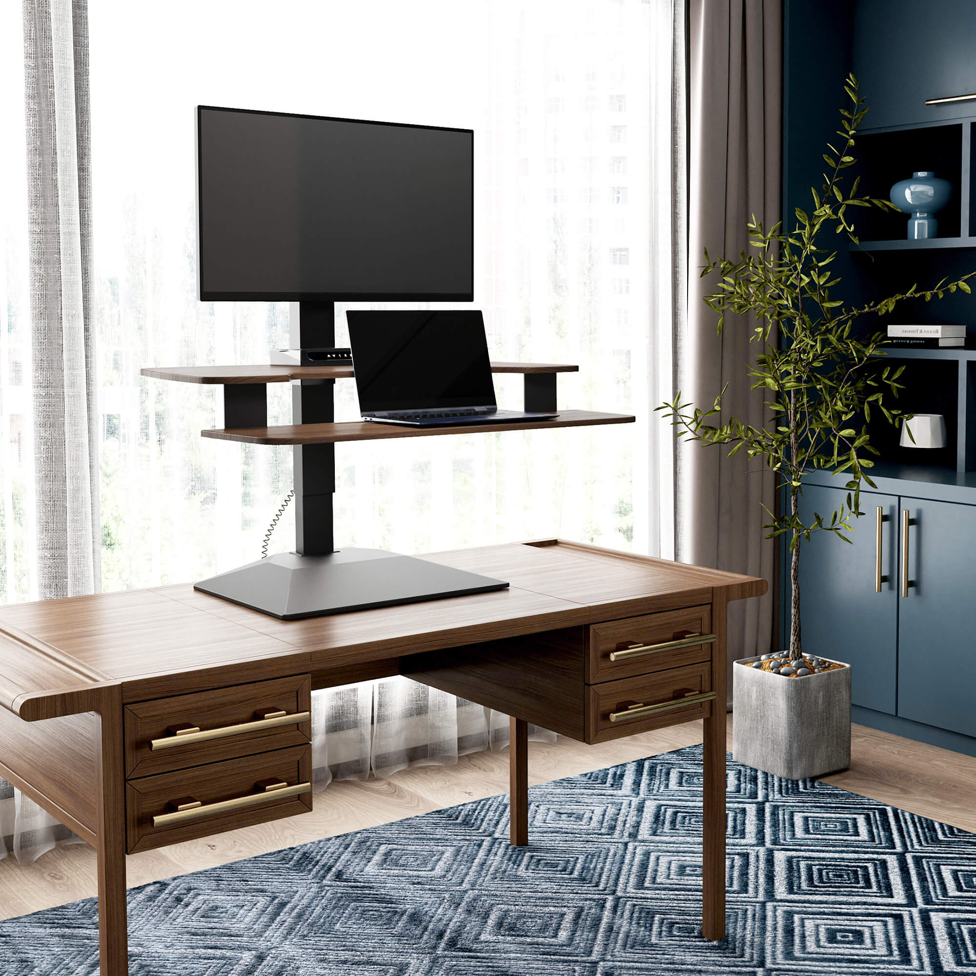 VariDesk Premier Electric Single-Monitor Series 2 in Walnut finish raised on a separate host desk with a single screen